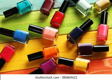Bottles of nail polish on a colorful wooden table - Shutterstock ID 380869621