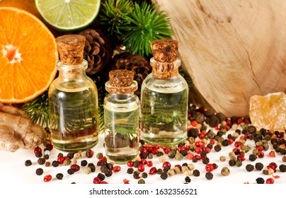 Bottles of oil with wooden stump (cut log), different peppercorns, fir branches, ginger root, orange and lime fruits. Spicy wooden fragrance or massage oil concept. - Shutterstock ID 1632356521