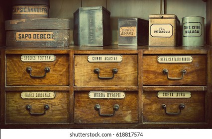 Bottles On The Shelf In Old Pharmacy. The Labels On Bottles And A Shelf  Inscription In Latin Language. Translation: Gum Arabic, Chalk White, Turmeric Root, Thoracic Collecting, Soap, Mustard, Cocoa.