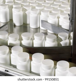 Bottles Preparing To Be Labeled In A Pharmaceutical Processing Facility.