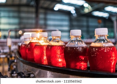 Bottles of red soda in the factory line. - Powered by Shutterstock