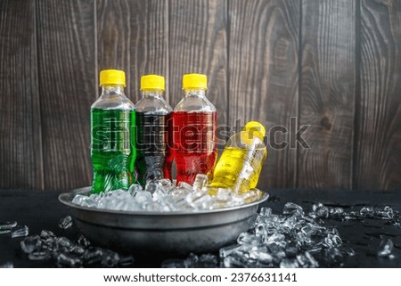 a lot of bottles of Soft drinks in colorful Chilled on ice and flavorful on the ice cubes background, Soft drink bottles or Carbonated beverages on ice