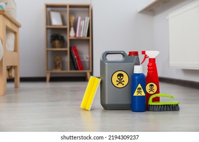 Bottles of toxic household chemicals with warning signs, brush and scouring sponge in room, space for text - Shutterstock ID 2194309237