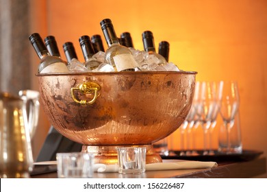 bottles of white wine standing in ice bowl on bar counter