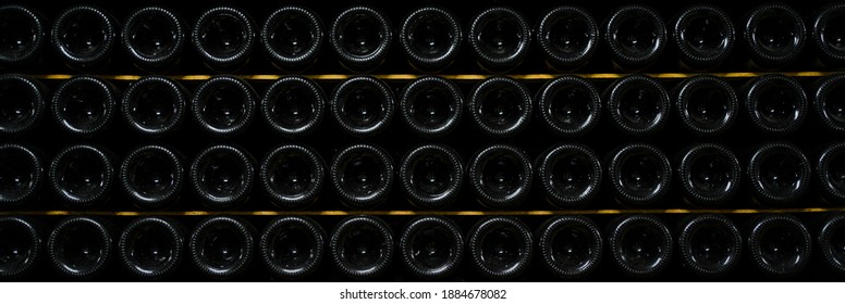 bottles of wine and champagne are stored underground in the winery. texture background. wine cellar.