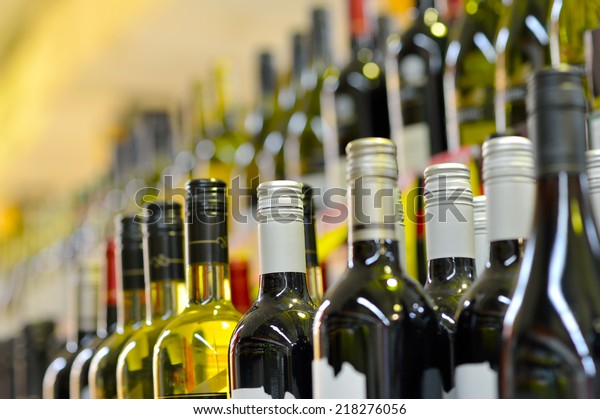 Bottles\
of wine in rows in liquor store, selective\
focus.