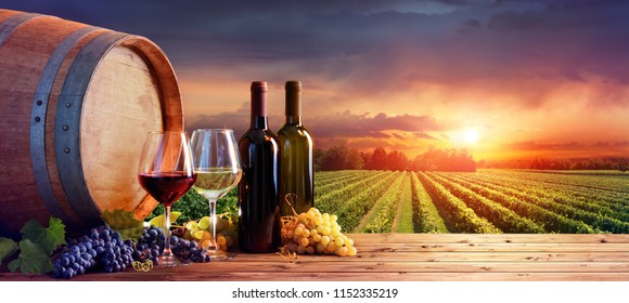 Bottles And Wineglasses With Grapes And Barrel In Rural Scene
