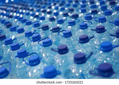 Lot of bottles worth with clean cool natural water. Group of plastic bottles with water stand in a row.
