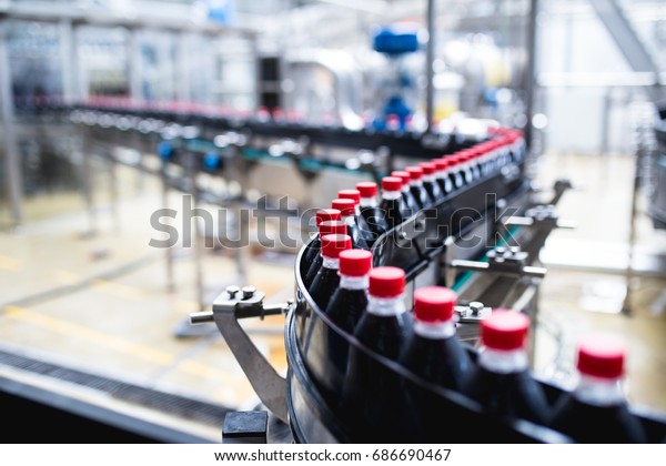 Bottling factory -\
Black juice bottling line for processing and bottling juice into\
bottles. Selective focus.\
