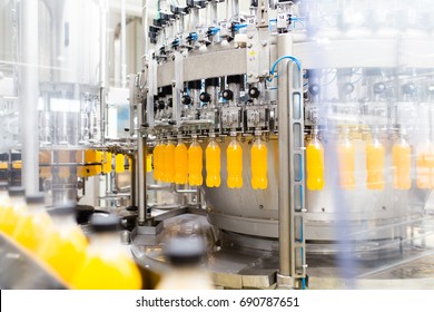 Bottling factory - Orange juice bottling line for processing and bottling juice into bottles. Selective focus.  - Powered by Shutterstock