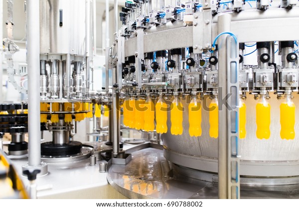 Bottling factory -\
Orange juice bottling line for processing and bottling juice into\
bottles. Selective focus.\
