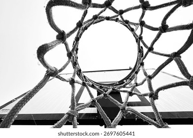 Bottom angle view of empty basketball net. Black and white photo.