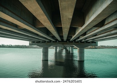 the bottom of a bridge or bridge support pillars that are in water - Powered by Shutterstock