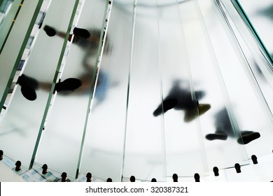 Bottom Up Floor View Of Walking Feet On Spiral Staircase. Walking People At Glass Stairs. Financial And Business Background. Building Career.