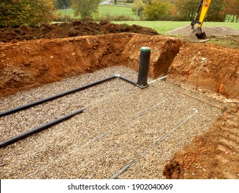 Bottom layer of pipework being covered in gravel, prior to the membrane and sand being applied, during the construction of a sand and gravel drainage system