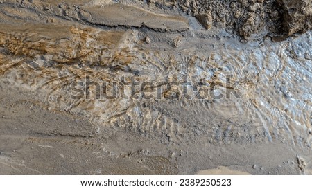 The bottom of the river with fine sand. Current, waves and wind. Sun glare. Water background. Gold mining, Close up.