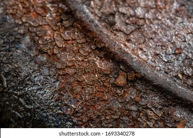 Bottom Side Of A Cast Iron Pan Close-up. Macro Photo Of A Rusty Pan With Soot.