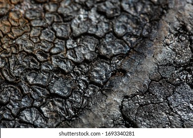 Bottom Side Of A Cast Iron Pan Close-up. Macro Photo Of A Rusty Pan With Soot.