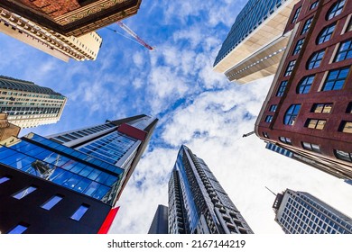 Bottom up view along tall high-rise tower buildings in City of Sydney downtown CBD against blue sky on a sunny day.