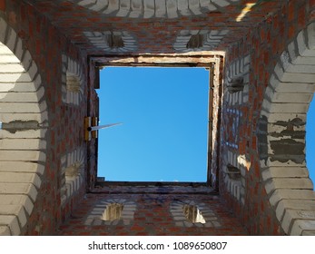 Bottom view of blue sky and clouds through the roof of abandoned building