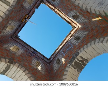 Bottom view of blue sky and clouds through the roof of abandoned building