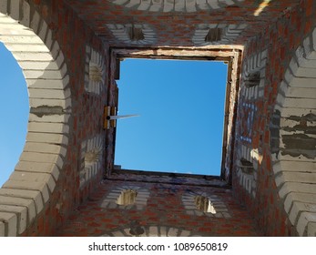 Bottom view of blue sky and clouds through the roof of abandoned building
