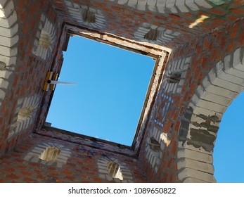 Bottom view of blue sky and clouds through the roof of abandoned building
