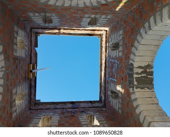 Bottom view of blue sky and clouds through the roof of abandoned building