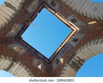 Bottom view of blue sky and clouds through the roof of abandoned building