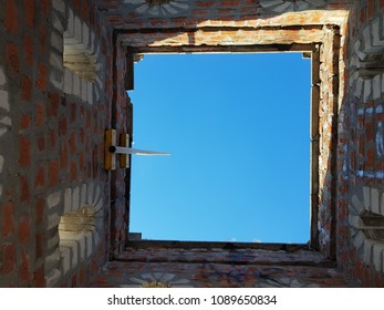 Bottom view of blue sky and clouds through the roof of abandoned building