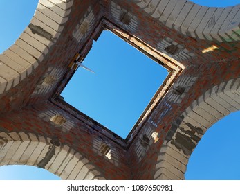 Bottom view of blue sky and clouds through the roof of abandoned building