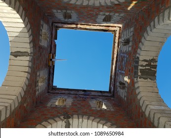 Bottom view of blue sky and clouds through the roof of abandoned building