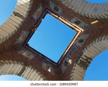 Bottom view of blue sky and clouds through the roof of abandoned building