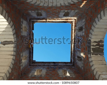 Bottom view of blue sky and clouds through the roof of abandoned building