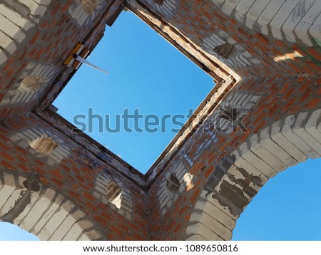 Bottom view of blue sky and clouds through the roof of abandoned building