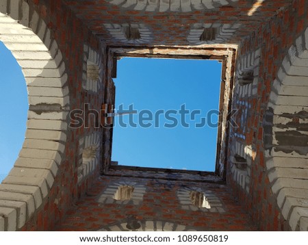 Bottom view of blue sky and clouds through the roof of abandoned building