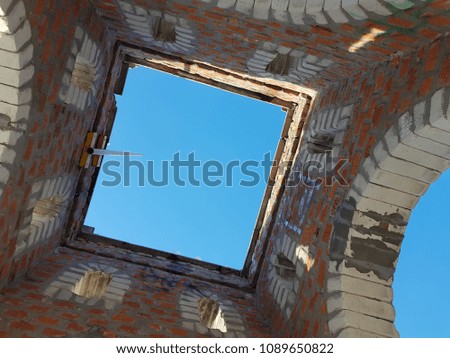 Bottom view of blue sky and clouds through the roof of abandoned building