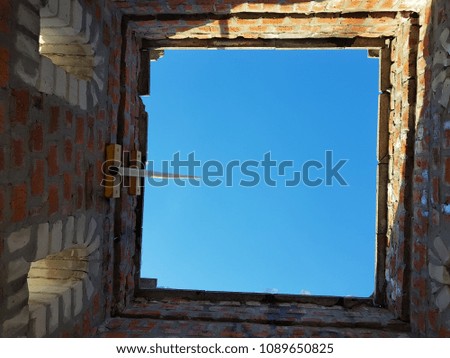 Bottom view of blue sky and clouds through the roof of abandoned building