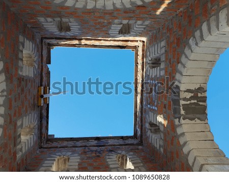 Bottom view of blue sky and clouds through the roof of abandoned building
