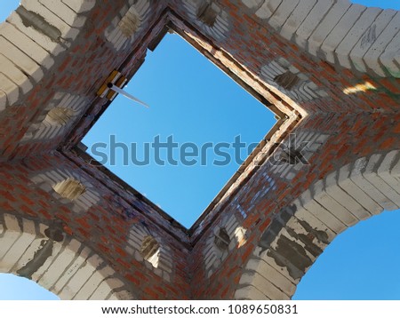 Bottom view of blue sky and clouds through the roof of abandoned building