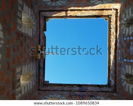 Bottom view of blue sky and clouds through the roof of abandoned building