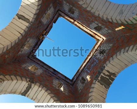 Bottom view of blue sky and clouds through the roof of abandoned building
