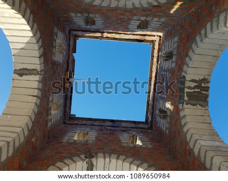 Bottom view of blue sky and clouds through the roof of abandoned building