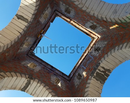 Bottom view of blue sky and clouds through the roof of abandoned building