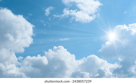 Bottom up view of blue sky with shining sun. White fluffy clouds on a blue sky in spring season. - Powered by Shutterstock