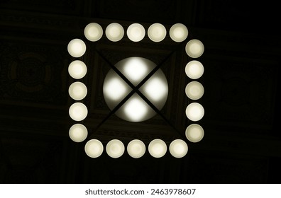 bottom view of a ceiling lamp with 20 small bulbs and one large bulb