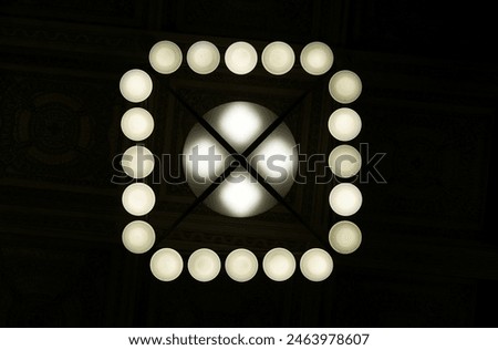 bottom view of a ceiling lamp with 20 small bulbs and one large bulb