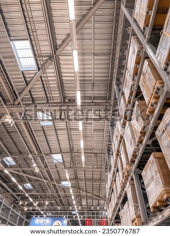 Bottom view of ceiling in warehouse with high shelves and boxes