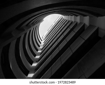 Bottom view of circular car parking garage against the sky. Automated circular parking system. Abstract shadow and sunset light shines through circular car parking garage. Selective focus. - Powered by Shutterstock