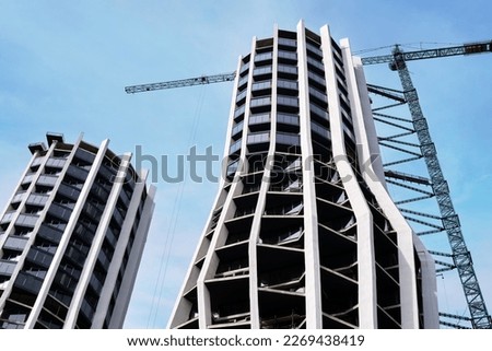 Bottom view of the construction of a new residential skyscraper with an interesting design.